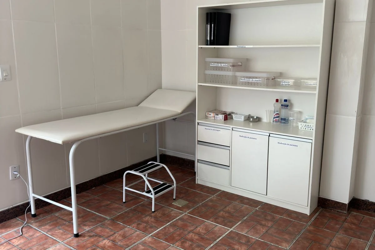 Sala de atendimento com maca e armário de materiais